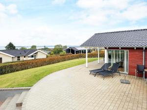 un patio con 2 sillas y una casa en 6 person holiday home in Faaborg en Bøjden