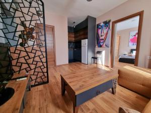 ein Wohnzimmer mit einem Tisch und einem Sofa in der Unterkunft ELISA Apartment 20A Center-Skopje in Skopje