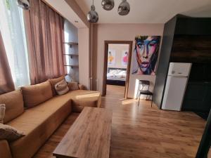 ein Wohnzimmer mit einem Sofa und einem Tisch in der Unterkunft ELISA Apartment 20A Center-Skopje in Skopje