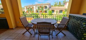 une table et des chaises sur un balcon avec une maison dans l'établissement Casa Il Pescatore, à Porto Pozzo