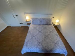 una camera da letto con un letto con un piumone blu e due lampade di B&B Irpinia Relais a Passo di Mirabella