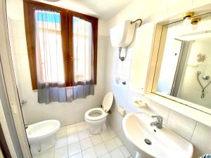 フォッローニカにあるappartamento Via Siena 1の白いバスルーム(トイレ、シンク付)