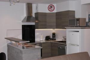 a kitchen with a stove and a microwave at Résidence les Charmettes in Mers-les-Bains +9 photos