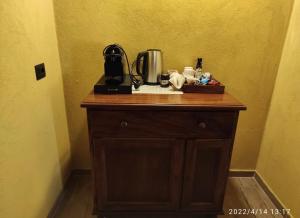 een houten dressoir met een koffiezetapparaat. bij Le camere del Tiglio in Treiso