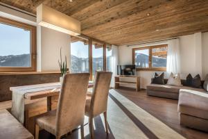 a living room with a table and chairs and a couch at Appartements Chalet Bandiarac in San Cassiano