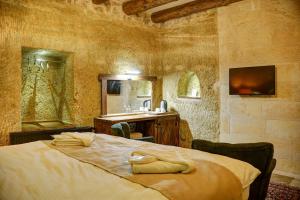 a bedroom with a large bed and a sink at Dionysos Cave Cappadocia Hotel in Urgup