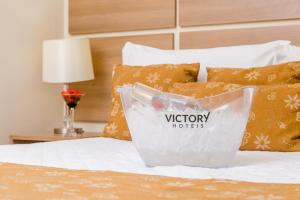 um recipiente de plástico sentado em cima de uma cama em Victory Suites em Juiz de Fora