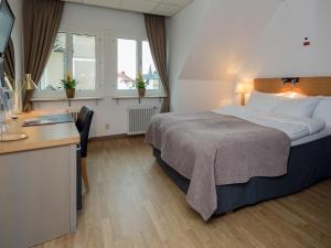 Rúm í herbergi á Grand Hotel Falkenberg