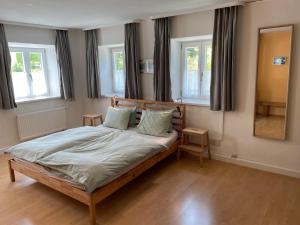 a bedroom with a large bed with two windows at Ferienwohnung Wagnerhaus in Bad Reichenhall