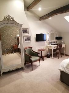 a bedroom with a bed and a desk and a mirror at The Black Swan in Glazebrook