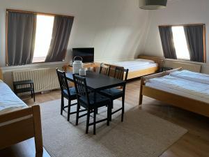 een kamer met een tafel en stoelen en 2 bedden bij Hotel De Oude Molen in Groesbeek