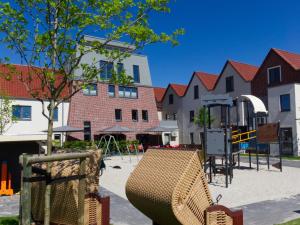 a park with a playground and buildings at Hotel Deichkrone - Familotel Nordsee in Norddeich