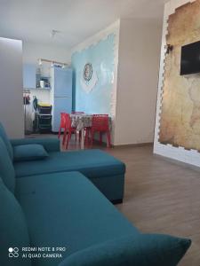 una sala de estar con sofás azules y una mesa. en Rosa dei Venti house, en Campomarino