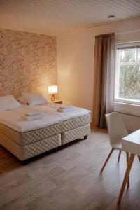 - une chambre avec un grand lit et une fenêtre dans l'établissement Mansikkaniemen Lomakeskus, à Rantasalmi