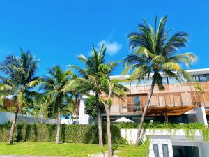 a building with palm trees in front of it at Phoenix Pool Villa Phu Quoc in Phú Quốc