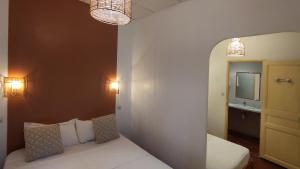a room with a bed and a mirror and lights at Logis Hôtel & Restaurant du Parc in Gémenos +7 photos