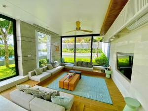 a living room with a couch and a table at Phoenix Pool Villa Phu Quoc in Phú Quốc