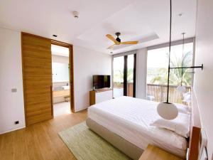 a bedroom with a large bed with a ceiling fan at Phoenix Pool Villa Phu Quoc in Phú Quốc