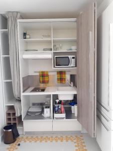 une cuisine avec un meuble blanc avec un micro-ondes dans l'établissement GRAND TI-BOU Gwada breizh, à Saint-François