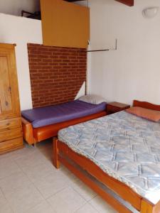 a bedroom with two beds and a brick wall at Alojamientos frente al Mar Complejo "El Estar De La Costa" in San Clemente del Tuyú