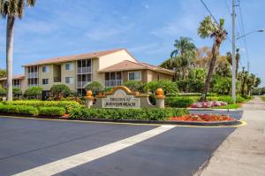 a hotel with a sign in front of a building at Luxurious Apartments with Pool and Gym at Boynton Beach in Boynton Beach