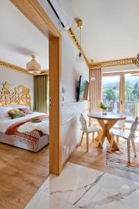 Schlafzimmer mit einem Bett und einem Tisch in der Unterkunft Rezydencja Górska Odkryj Zakopane in Zakopane