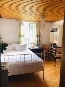 een slaapkamer met een bed, een bureau en een raam bij Trad. Blackforest House in Ettenheim