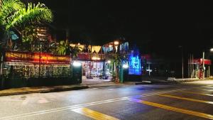 una calle vacía por la noche con un edificio con luces en Forest Paradise Inn Teluk Bahang PRIVATE MALAY TRADITIONAL HOUSE CONCEPT HOTEL en Teluk Bahang