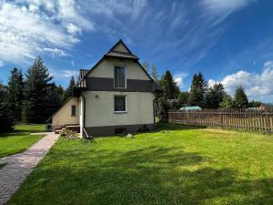 a house with a gambrel roof on a yard at Samsolandia Willa Falsztyn in Falsztyn