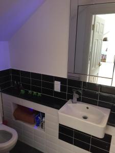 a bathroom with a sink and a toilet and a mirror at Spacious, modern 3 bedroom luxury flat in centre location in Broughty Ferry