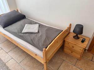 ブルノにあるRooms Orlíのベッド(グレーのマットレス、テーブルの上のランプ付)