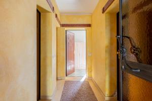 een hal met gele muren en een open deur bij Casa Olly in Montecatini Terme