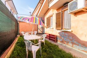 uma mesa e cadeiras com um guarda-sol numa varanda em Casa Olly em Montecatini Terme