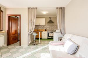een woonkamer met een witte bank en een keuken bij Casa Olly in Montecatini Terme