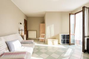 uma sala de estar com um sofá branco e piso em azulejo em Casa Olly em Montecatini Terme