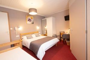 a hotel room with a large bed and a desk at HOTEL RESTAURANT LE CENTRE in Lélex