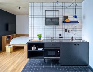een keuken met een wastafel en een bed in een kamer bij STAYERY Köln Ehrenfeld in Keulen