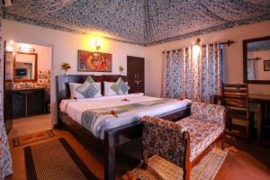 a bedroom with a bed and a table and a chair at Ranthambhore Heritage Haveli in Sawāi Mādhopur