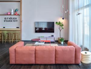 a living room with a pink couch and a table at STAYERY Köln Ehrenfeld in Cologne