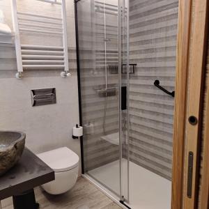 La salle de bains est pourvue de toilettes et d'une douche en verre. dans l'établissement Treselcorral, à Sotres