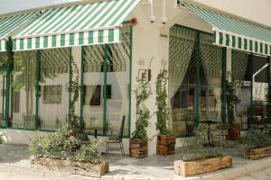 a store front with tables and chairs and plants at Garden Downtown Prishtina in Prishtinë