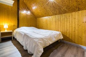 a bedroom with a bed in a wooden wall at Chalets de la Wormsa in Metzeral