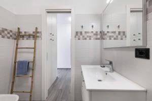 een witte badkamer met een wastafel en een ladder bij Cà de Anto in Cisano sul Neva