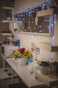 un bancone della cucina con fiori e luci sopra di 4 Couples & 4 Friends Hostel a Cracovia