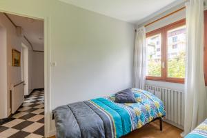 een slaapkamer met een bed en een geruite vloer bij Chalet Les Tourelles in Aix-les-Bains