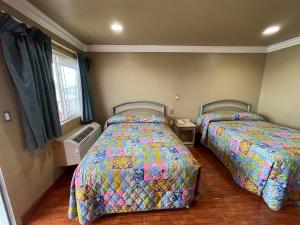 1 Schlafzimmer mit 2 Betten und einem Fenster in der Unterkunft Hiland Motel in Long Beach