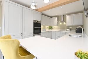 a kitchen with white cabinets and a white counter top at Bage Mine Barn in Wirksworth