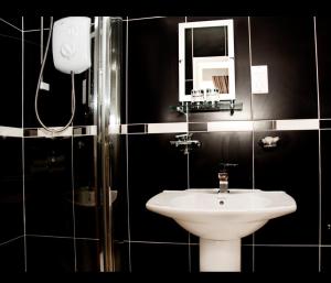 uma casa de banho preta com um lavatório e um espelho em The Georgian Town House Hotel em Liverpool