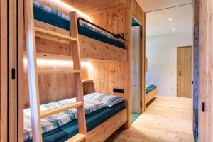 ein Schlafzimmer mit Etagenbetten in einem Holzhaus in der Unterkunft Hof im Thal Apt Linde in Aldino