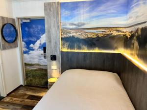 Bett in einem Zimmer mit Wandgemälde in der Unterkunft Hotel Nap in West-Terschelling